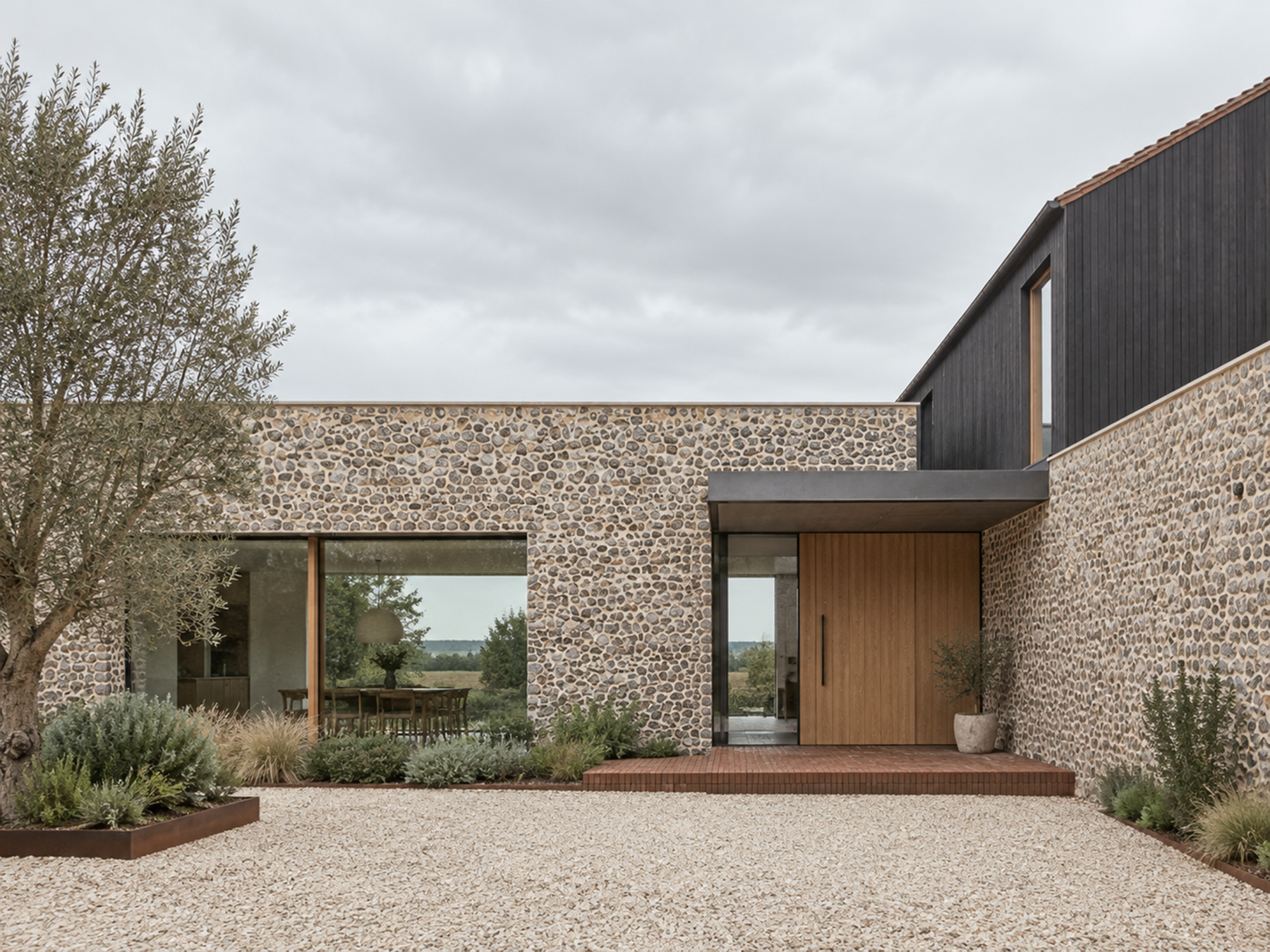 Contemporary home with flint walls and a landscaped entrance